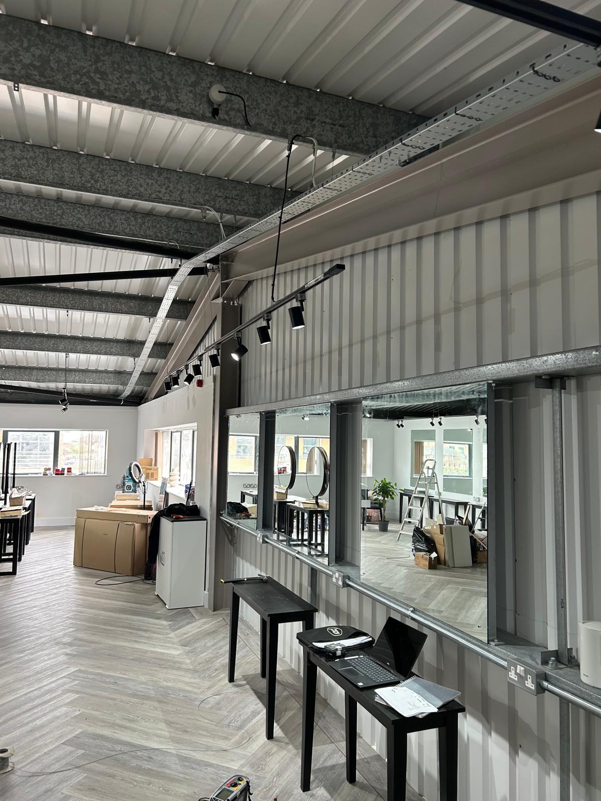 Commercial retail fit-out with track lighting and full-height mirrors