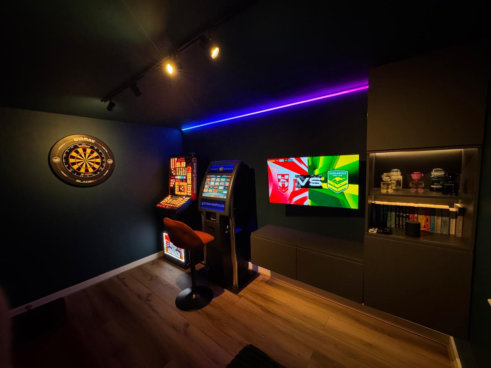 Games room with wall-mounted television, dartboard and integrated colour lighting