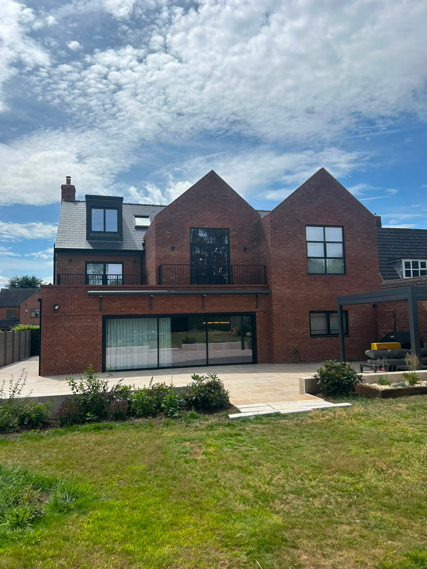 Exterior of a modern red brick home fitted with a smart home automation system