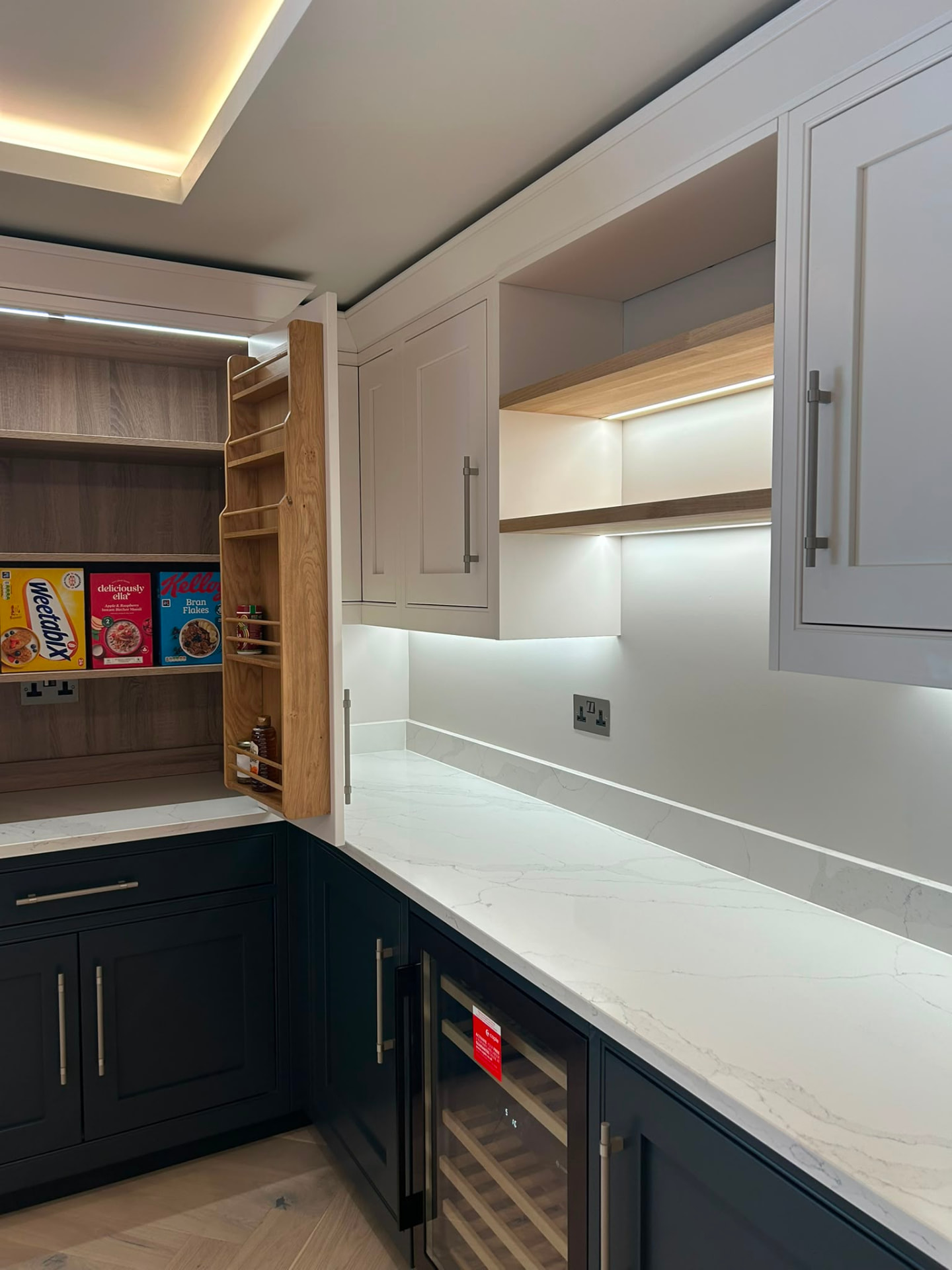 Under-cabinet LED lighting in a modern navy and white kitchen